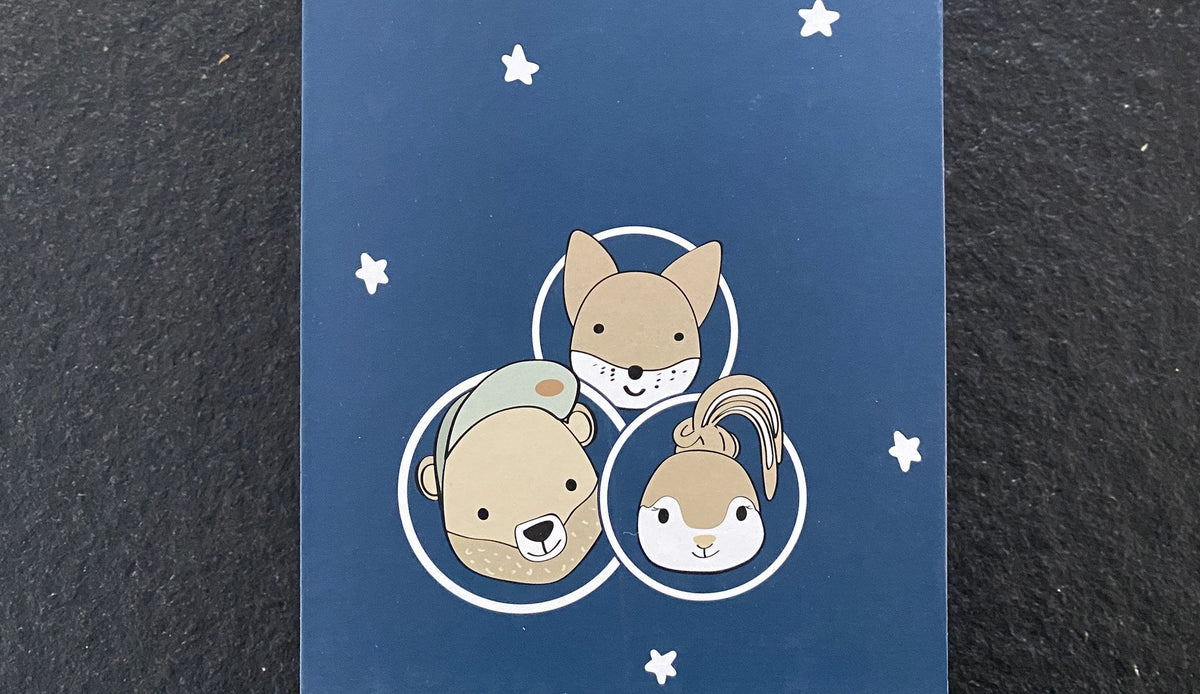 Dunkelblaue Geschenkbox von Rock my Sleep mit den Rockies Bär, Fuchs und Häsin in weißen Kreisen zwischen Sternen