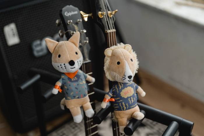 Eddie der Löwe und Peter der Fuchs vor einer Gitarre